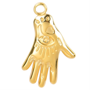 Detailed close-up of a gold Hamsa Hand pendant with engraved evil eye and heart patterns