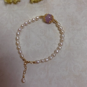 Detail of baroque pearl bracelet with gold plating, purple bead and adjustable chain
