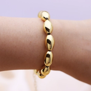 Minimalist 18k gold-plated olive bead bracelet on woman wrist with lobster clasp