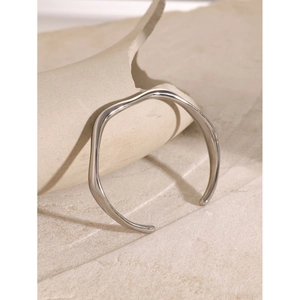 Minimalist silver wavy open cuff bracelet in polished stainless steel on stone base