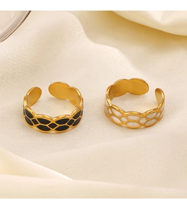 Detail of 18K gold plated rings with black and white enamel grid patterns on silk