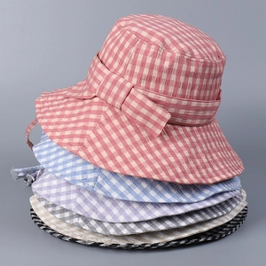 Detailed stack of colorful checkered sun hats in pink, blue, purple, and gray colors