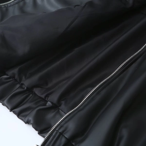 Detailed macro view of the metal zipper and high-quality PU leather texture on the jacket