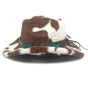 Détail d'un chapeau de cowboy à imprimé vache avec bandeau en cuir brodé turquoise