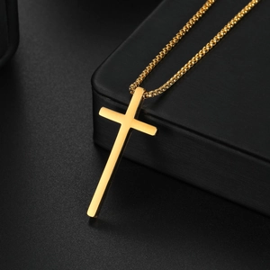 Minimalist gold cross pendant necklace for men with box chain over black jewelry box