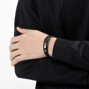 Close-up of men's multilayer black braided leather bracelet with stainless steel clasp