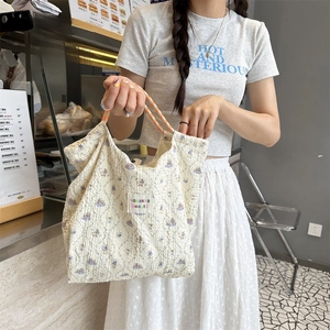 Detail of quilted floral canvas tote bag featuring a cute cartoon rabbit and woven handle