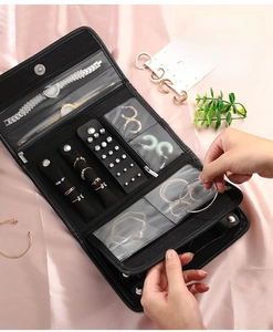 Detail of black jewelry bag with transparent PVC pockets and earring snap storage board