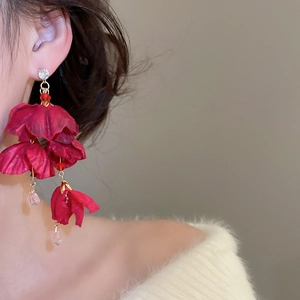 Detail von roten Blumenohrringen mit Stoffblüten und tropfenförmigen Kristallperlen