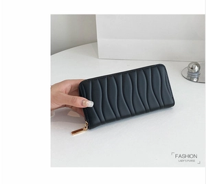 Detail of black wave quilted long purse with premium golden zipper and soft texture