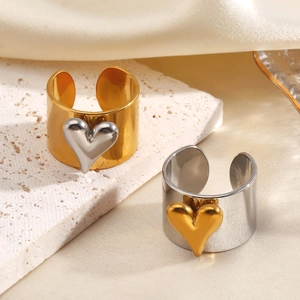 Bagues cœur en acier inoxydable or et argent sur une surface en pierre chic