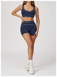 Detail of navy blue sports set featuring white contrast stitching on vest and shorts