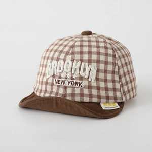 Detail of baby soft brim baseball cap with brown gingham pattern and Brooklyn embroidery