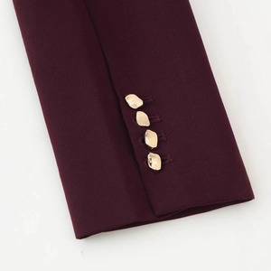 Tailleur bordeaux pour femme avec détail des poignets et quatre boutons dorés en métal