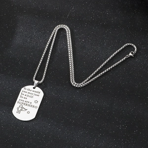 Detail of engraved stainless steel dog tag pendant with superhero dad quote on black background