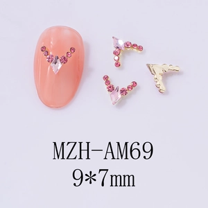 Macro detail of V-shaped pink crystal nail charms with gold base in 9x7mm size