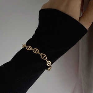 18k gold plated titanium steel pig nose chain bracelet worn over black knit sleeve