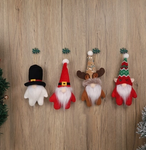 Lot de quatre gnomes de Noël artisanaux en peluche sur fond de bois naturel