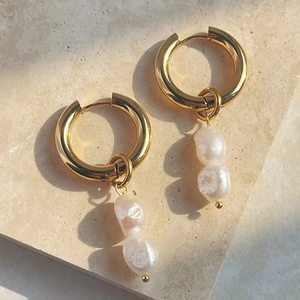 Detail of 18K gold stainless steel hoop earrings with baroque pearls on stone