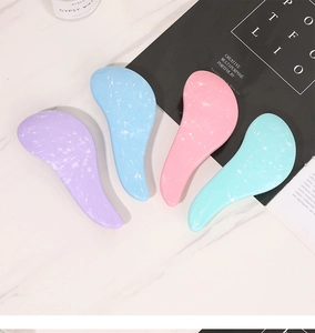 Flat lay of macaron-colored hairbrushes with marble texture in purple, blue, pink, and cyan