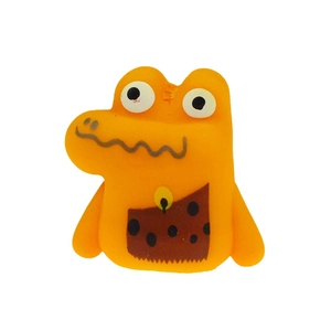Macro detail of an orange TPR cartoon dinosaur finger puppet with large eyes and soft texture