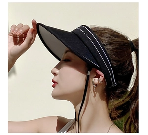 Detail view of black sun visor with white SHINE embroidery and adjustable windproof cord