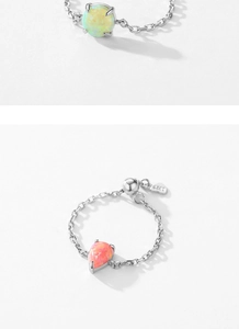 Close-up of 925 sterling silver rings with round opal and pink teardrop stones