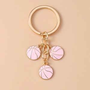 Detail of three pink enamel basketball charms on a gold-plated keychain holder
