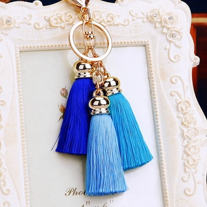 Close-up of three-tier blue silk tassels with gold metal ring and lobster clasp
