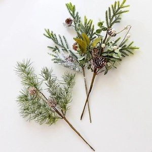 Artificial Christmas pine branches with pinecones and white berries on white background