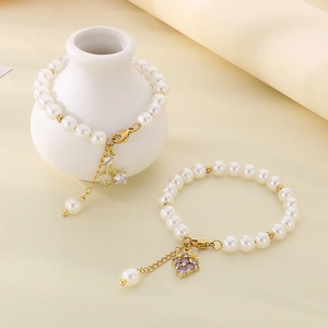 Detailed shot of pearl bracelets with sparkling cherry and grape zircon pendants