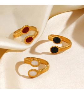 Macro shot of gold-plated geometric rings with colorful oval resin on white silk