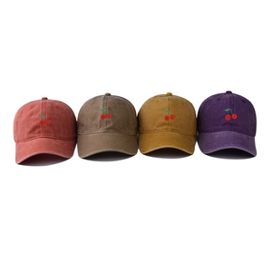 Detail of four washed cotton baseball caps with cherry embroidery in various vintage colors
