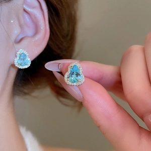 Gros plan de boucles d'oreilles gourde en zircon bleu clair avec pavé de pierres brillantes