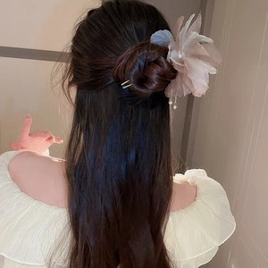Détail de l'épingle à cheveux fleur en tulle rose avec pompons de perles élégants