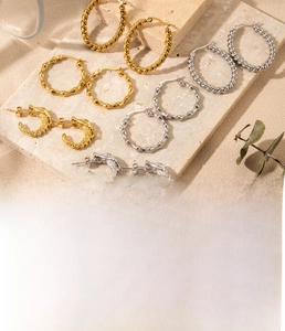 Detailed close-up of textured twist and bamboo style stainless steel C-shaped earrings