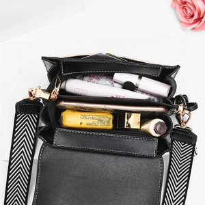 Black women's crossbody shoulder bag with chevron pattern strap and gold hardware