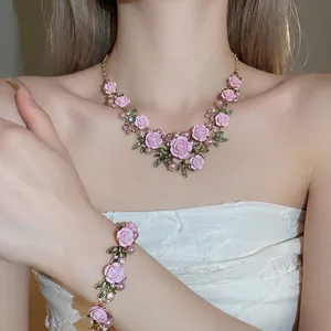 Elegant pink rose necklace and bracelet set with pearls and rhinestones on a golden chain