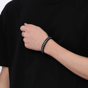 Close-up of men's black woven leather bracelet with magnetic stainless steel clasp detail