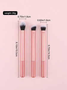 Trois pinceaux de maquillage or rose avec poils synthétiques et dimensions sur fond rose