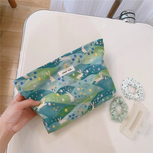 Close-up of floral bunny print canvas makeup bag with a 'simple wish' woven cotton label