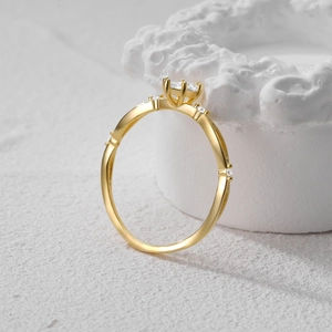 Dettaglio ravvicinato di un anello dorato con diamante a taglio quadrato e piccoli accenti