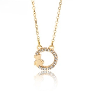 Macro detail of gold-plated necklace with micro-pave crystal ring and bear charm