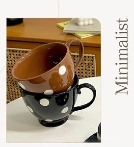 Gros plan sur des mugs en céramique rétro à pois blancs avec des poignées courbes élégantes
