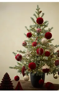 Close-up of festive red flocked ornaments and gold sequins on a green Christmas tree