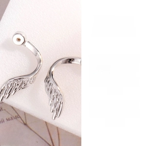 Detailed view of silver wing-shaped DIY earring charms with fine feather textures