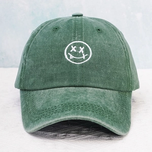 Vintage green washed cotton baseball cap with white embroidered tongue-out smiley face icon
