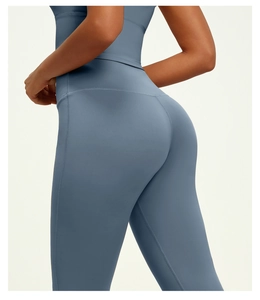 Detail shot of blue-grey high-waisted yoga pants showcasing elastic matte fabric and slim fit