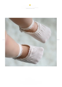 Detailed view of beige baby socks with delicate white lace trim and soft cotton fabric