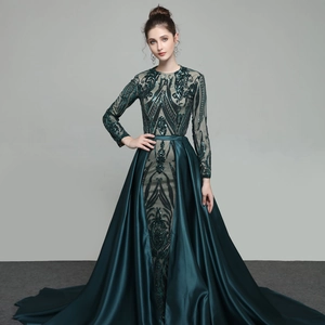 Detail of dark green sequin embroidery and elegant satin train on evening gown